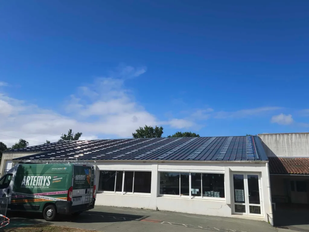 Panneaux solaires en surimposition sur la toiture en bac acier d'un bâtiment communal, Le Thou