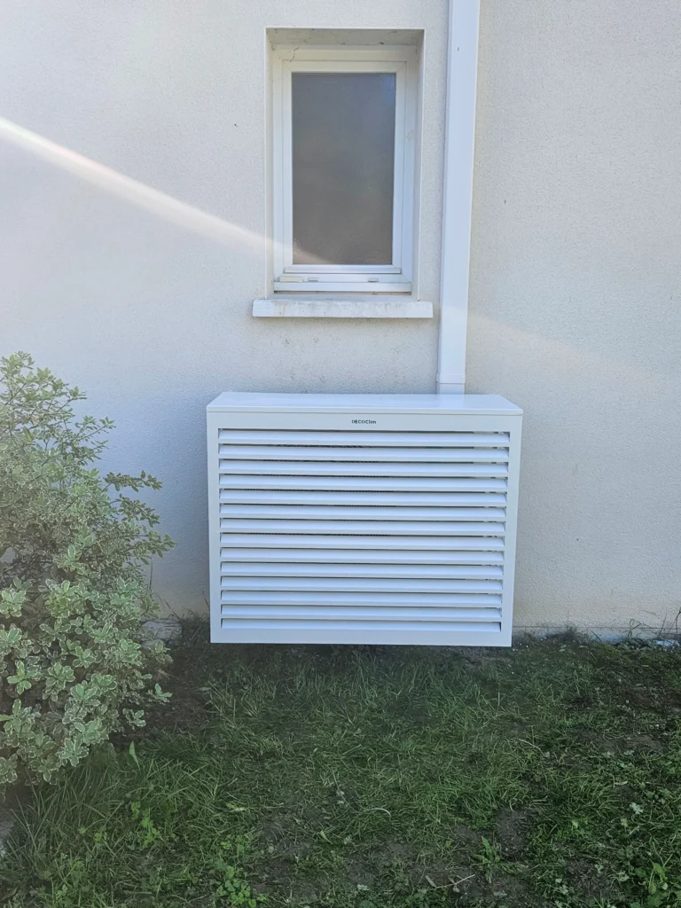 Cache-clim à lames blanc posé sur le groupe extérieur, sous une fenêtre, Benon