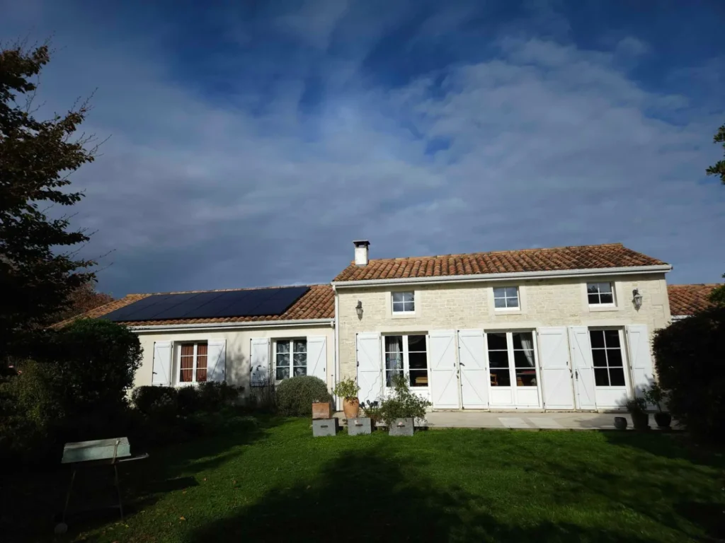 Maison avec douze panneaux solaires sur le toit, vue du jardin, La Foye-Monjault