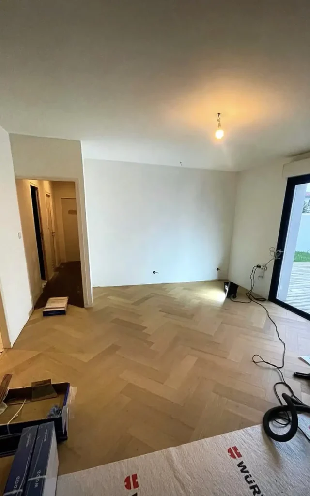 Pose du parquet en bâtons rompus en cours dans la pièce de vie