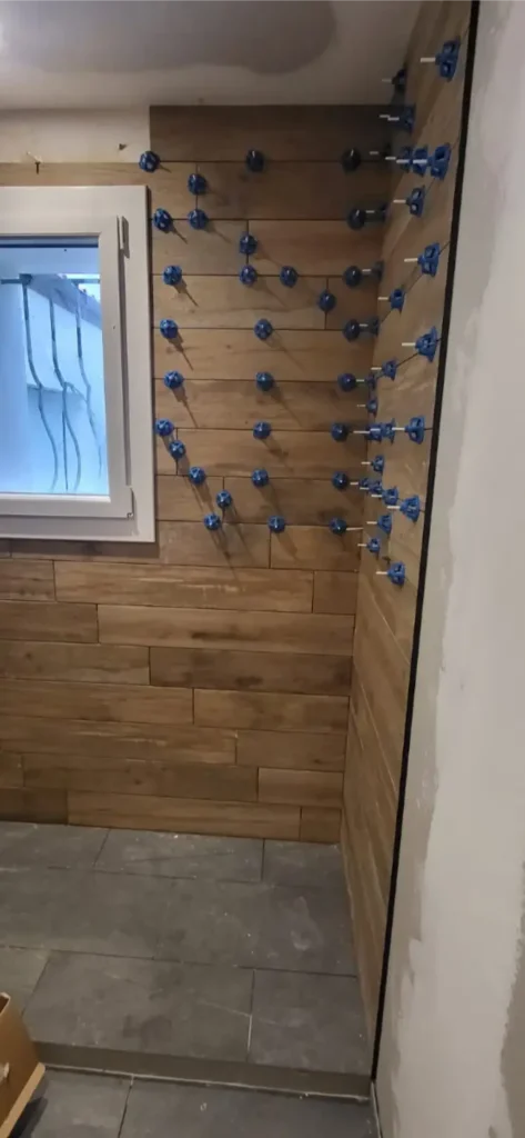 Salle de bain rénovée à Anais : meuble vasque suspendu et douche à l'italienne effet bois